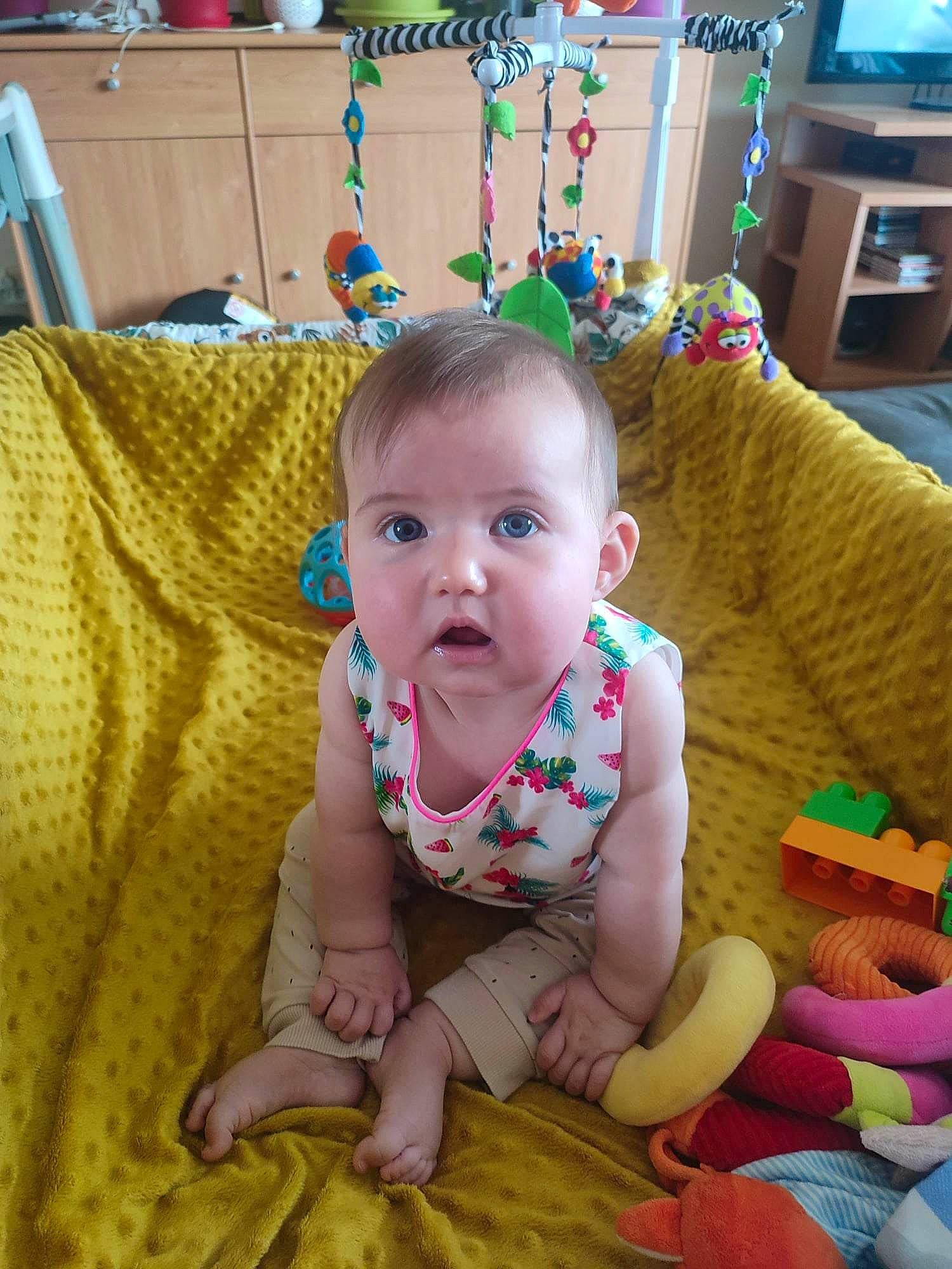 Ashley a rejoint le concours — aidez-le/la à gagner de superbes lots ! baby, baby_products, baby_toddler_clothing, cheek, child, comfort, flooring, fun, happy, head, iris, linens, person, play, room, sitting, skin, smile, surprise, toddler