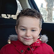 Wyatt participe au concours pour gagner de l'argent avec cette photo : blue_eyes, buttons, car_interior, car_seat, child, daylight, fur_hood, happy, headrest, kid, portrait, red_jacket, rosy_cheeks, short_hair, smiling, tree_outside, window, winter_clothing, young_child, zipper