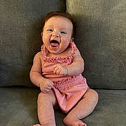 Maya joined the competition — help win amazing prizes! baby, infant, smiling, happy, pink_outfit, sitting, couch, furniture, indoor, child, cute, human, portrait, skin, feet, hands, expression, young, one_person, casual_clothing