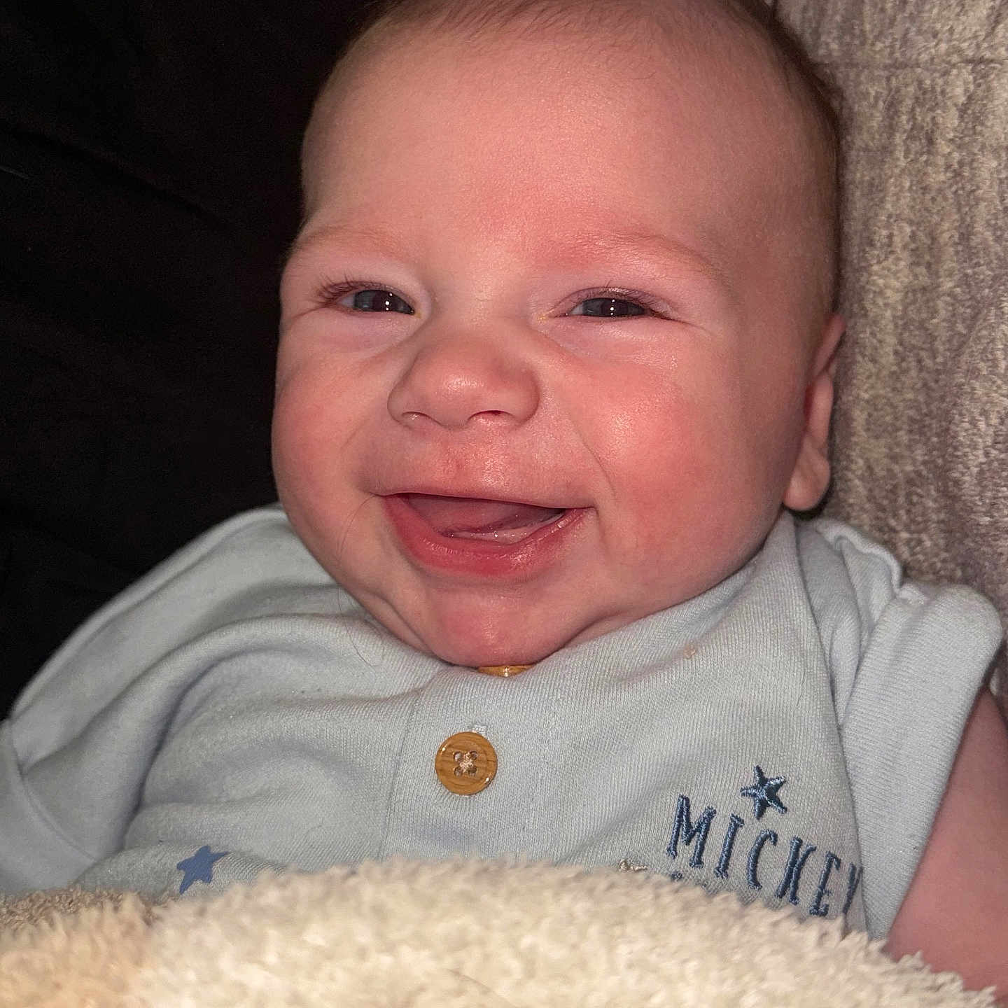 Jackson is registered to the contest to win money with this photo: baby, smile, face, infant, blanket, clothing, button, embroidery, happy, closeup, child, cute, soft_texture, indoors, person, portrait, newborn, cozy, light_blue, sleepwear