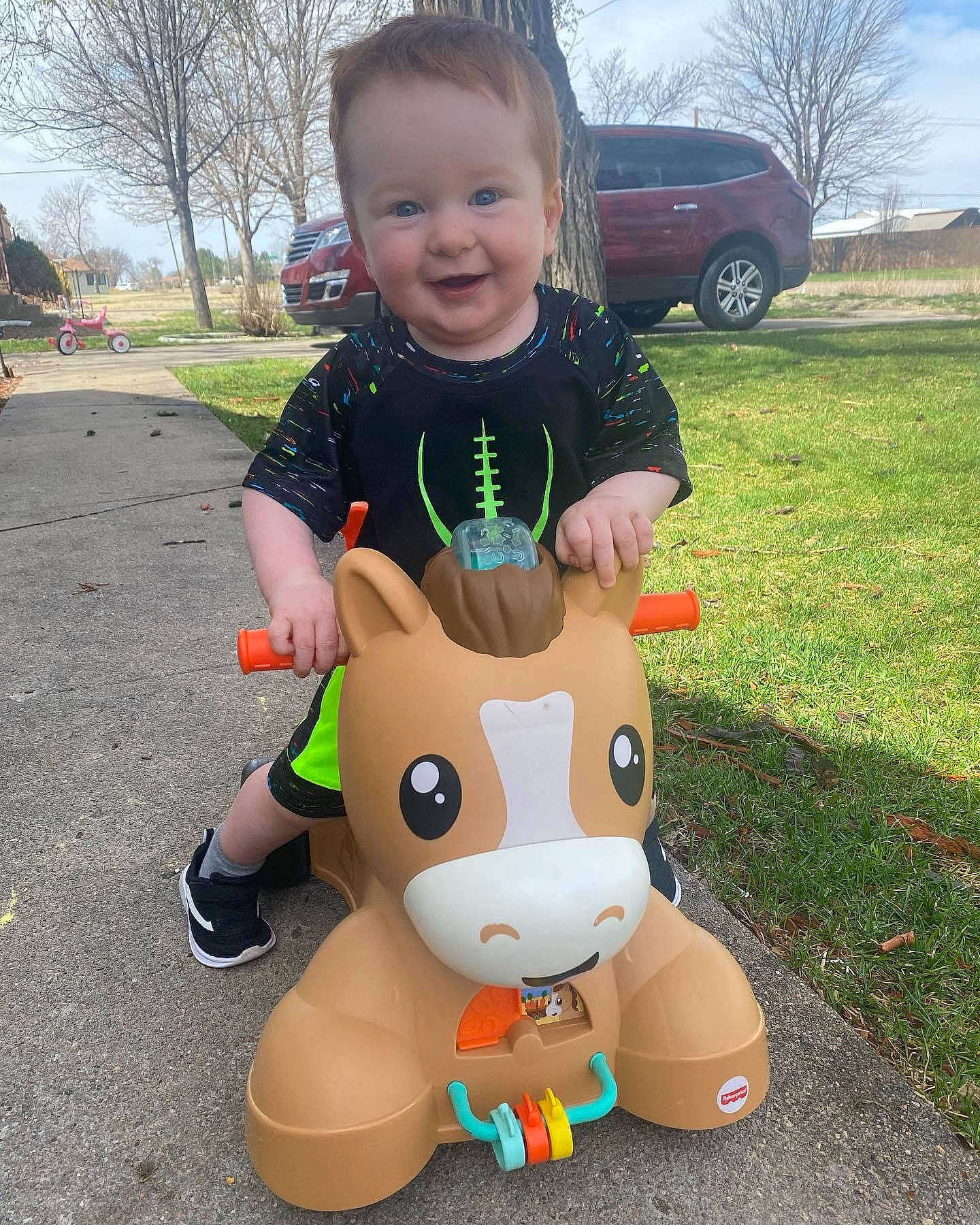Braden is registered to the contest to win money with this photo: child, eye, fawn, fun, grass, happy, head, joy, leg, leisure, mascot, person, recreation, sky, sleeve, smile, t_shirt, tire, toddler, toy