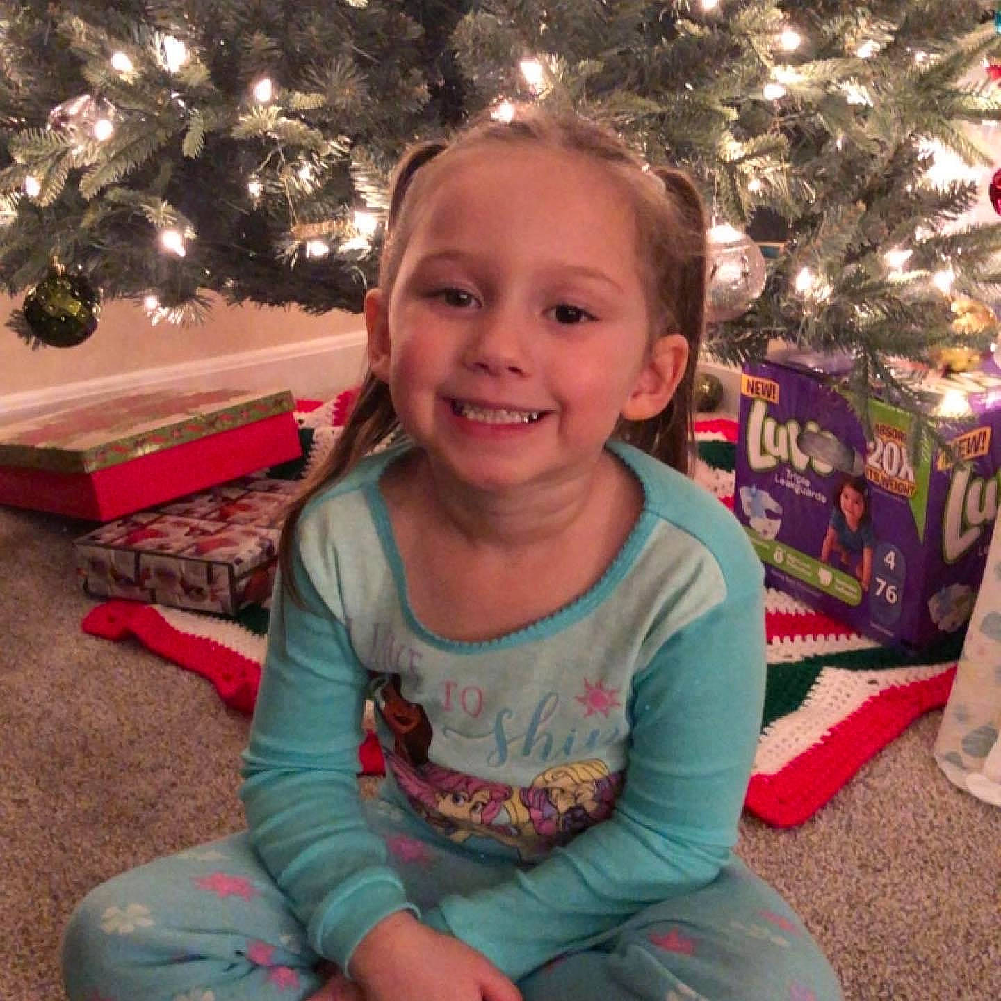 Wiley is registered to the contest to win money with this photo: baby_toddler_clothing, child, christmas_decoration, christmas_ornament, christmas_tree, cool, facial_expression, fun, happy, head, holiday_ornament, joy, lap, leaf, ornament, people, person, plant, sleeve, smile