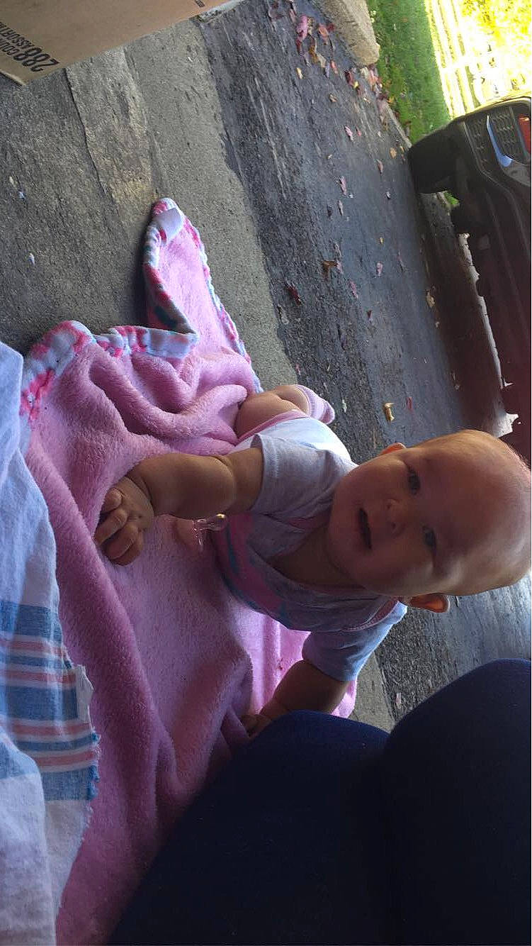 Constance is registered to the contest to win money with this photo: baby, baby_toddler_clothing, child, comfort, dress, elbow, finger, foot, fun, grass, human_leg, leisure, magenta, person, pink, purple, skin, thigh, thumb, toddler