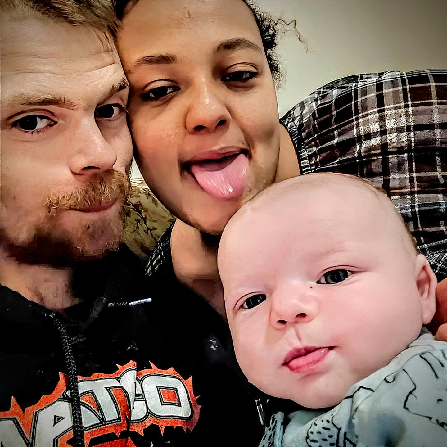 Lucus is registered to the contest to win money with this photo: baby, casual, closeup, clothing, curly_hair, expression, face, happy, hoodie, indoor, light_skin, man, people, plaid, playful, portrait, selfie, smile, tongue, woman