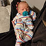 newborn, baby, pacifier, striped_clothing, sleeping, person, arms, mattress, bottle, indoor, resting, closeup, cute, infant, child, human, comfort, relaxation, sleep, bedroom
