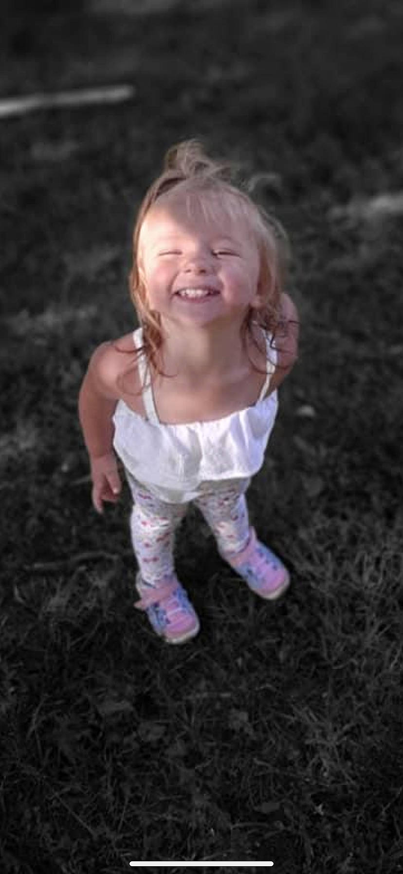 Ariana is registered to the contest to win money with this photo: baby_toddler_clothing, blond, face, flash_photography, fun, gesture, grass, hand, happy, human_body, joy, people_in_nature, person, plant, play, recreation, sitting, smile, soil, t_shirt