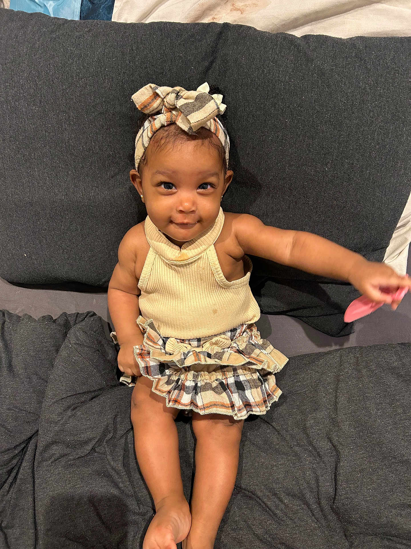 Iniyah is registered to the contest to win money with this photo: toddler, child, smile, headband, skirt, sitting, toy, couch, fabric, cute, happy, indoors, person, clothing, playful, baby, skin, foot, arm, portrait