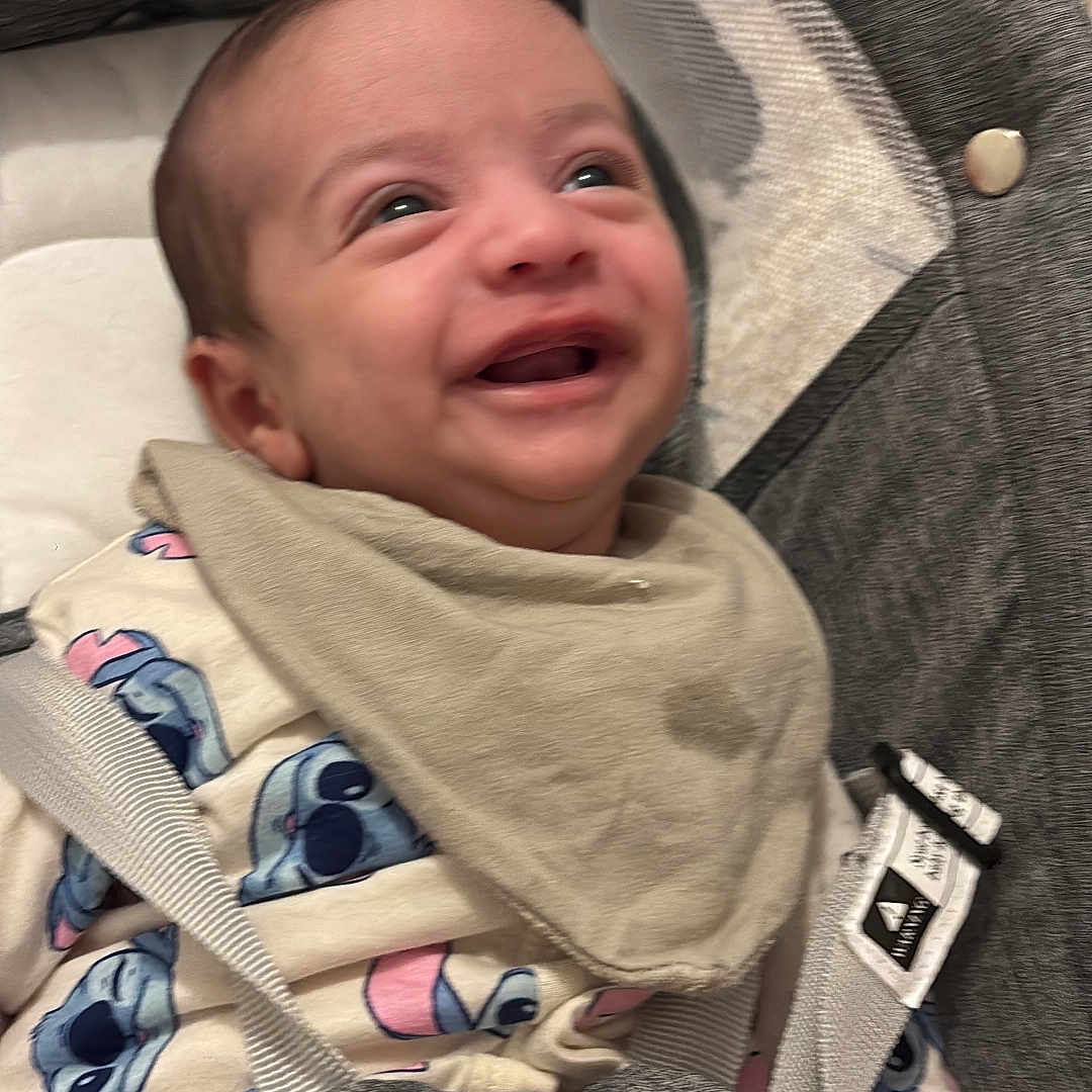 Eyan participe au concours pour gagner de l'argent avec cette photo : baby, baby_carrier, bib, child, clothing, comfort, cute, eyes, fabric, face, happy, head, indoors, infant, mouth, person, portrait, seatbelt, sitting, smiling