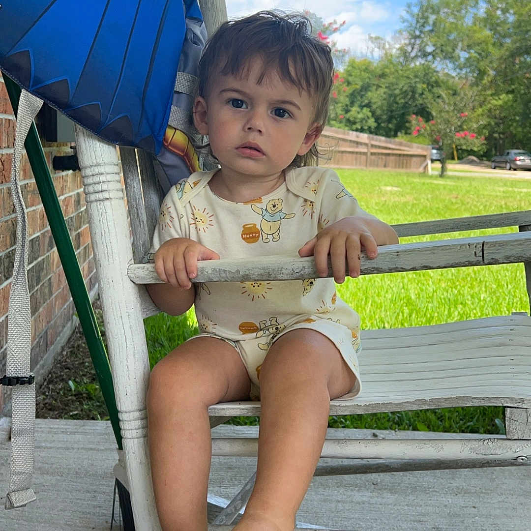 Kruz is registered to the contest to win money with this photo: baby, bench, bodypart, car, clothing, face, finger, furniture, grass, hand, head, outdoors, person, photography, plant, portrait, shorts, sitting, transportation, vehicle