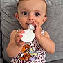 baby, child, infant, cute, smiling, leopard_print, cartoon, cat, ice_cream, couch, gray, clothing, sitting, holding, hand, face, eyes, indoors, young, playful