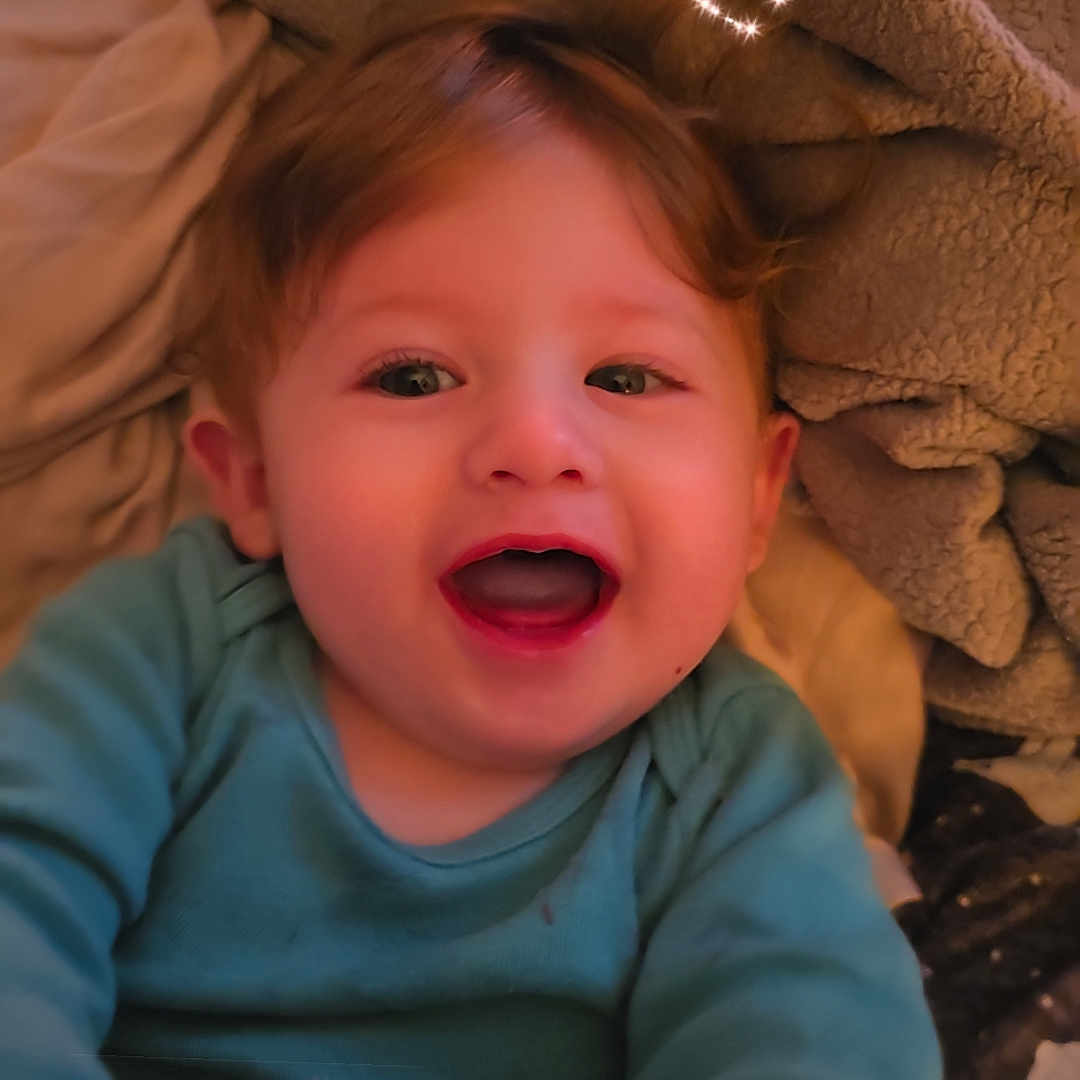 Sage is registered to the contest to win money with this photo: baby, blanket, child, clothing, cozy, cute, doodle, expression, face, happy, heart, indoors, infant, joy, portrait, smiling, soft, sparkle, toddler, warm