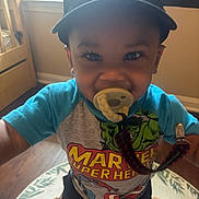 Kyrian joined the competition — help win amazing prizes! toddler, child, pacifier, marvel, superhero, shirt, cap, nike, smiling, indoors, rug, animal_print, floor, wooden_floor, window, baby, cute, happy, person, clothing