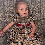 Willow is registered to the contest to win money with this photo: child, toddler, baby, portrait, sitting, armchair, dress, plaid, red_sash, tights, white_socks, blonde_hair, blue_eyes, indoors, window, sunlight, furniture, patterned_background, fashion, cute