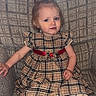 child, toddler, baby, portrait, sitting, armchair, dress, plaid, red_sash, tights, white_socks, blonde_hair, blue_eyes, indoors, window, sunlight, furniture, patterned_background, fashion, cute