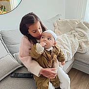 Isaia a rejoint le concours — aidez-le/la à gagner de superbes lots ! baby, blanket, child, couch, cousin, cozy, girl, hand_in_mouth, hat, holding, hugging, indoors, knit_sweater, living_room, mirror, pillow, portrait, remote_control, sibling, window