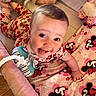 baby, smiling, tongue_out, strawberry_pattern, onesie, blanket, minnie_mouse, toy, bottle, soft_toy, infant, cute, lying_down, playpen, happy, child, indoors, colorful, face, closeup