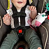 Hannah is registered to the contest to win money with this photo: baby, car_seat, child, smiling, toy, plush, unicorn, seatbelt, clothing, happy, infant, person, cute, safety, seat, indoors, young_child, legs, foot, hand