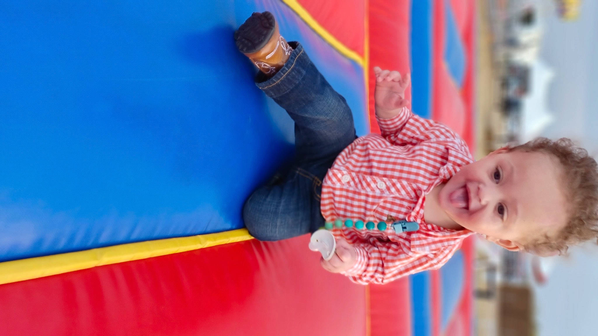 Nehemiah is registered to the contest to win money with this photo: arm, baby, bounce_house, child, electric_blue, event, fun, gesture, happy, human_body, leisure, outdoor_play_equipment, person, play, playground, recreation, red, room, smile, thumb