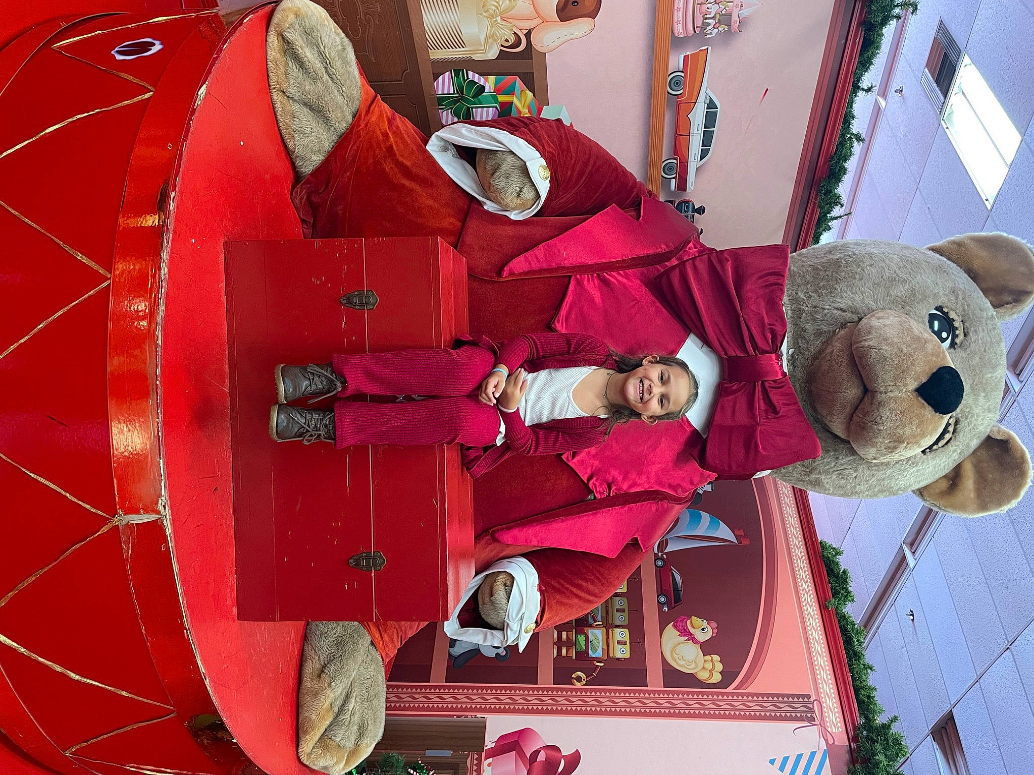 Khloe is registered to the contest to win money with this photo: automotive_wheel_system, carmine, circle, event, fun, joy, magenta, ornament, person, pink, product, red, room, smile, teddy_bear, textile, tire, toy, tree, vehicle