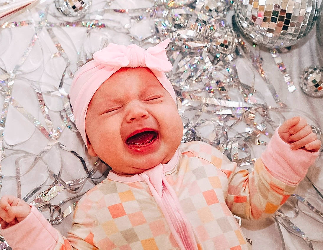 Riley joined the competition — help win amazing prizes! baby, baby_sleeping, baby_toddler_clothing, cheek, child, comfort, event, facial_expression, finger, fun, gesture, happy, headwear, human, laugh, mouth, pattern, person, pink, skin
