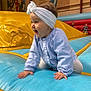 baby, child, headband, blue_shirt, inflatable, playground, happy, crawling, indoor, toy, fun, kids, colorful, smiling, play, young_child, people, background, mural, activity