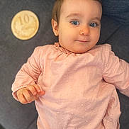 Charlize participe au concours pour gagner de l'argent avec cette photo : baby, child, blue_eyes, pink_clothing, couch, milestone_plaque, hand, nail_art, orange_nails, person, portrait, indoor, cute, smiling, face, young_child, sitting, soft_lighting, home, cozy