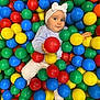 Charlize a rejoint le concours — aidez-le/la à gagner de superbes lots ! baby, child, ball_pit, colorful_balls, red_balls, green_balls, blue_balls, yellow_balls, white_headband, bow, striped_shirt, white_pants, barefoot, play, fun, indoor, cute, smiling, portrait, leisure