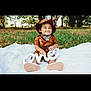 child, toddler, smiling, outdoor, grass, blanket, hat, birthday, one, sign, brown_clothing, bandana, shoes, nature, trees, cute, portrait, celebration, sitting, happy