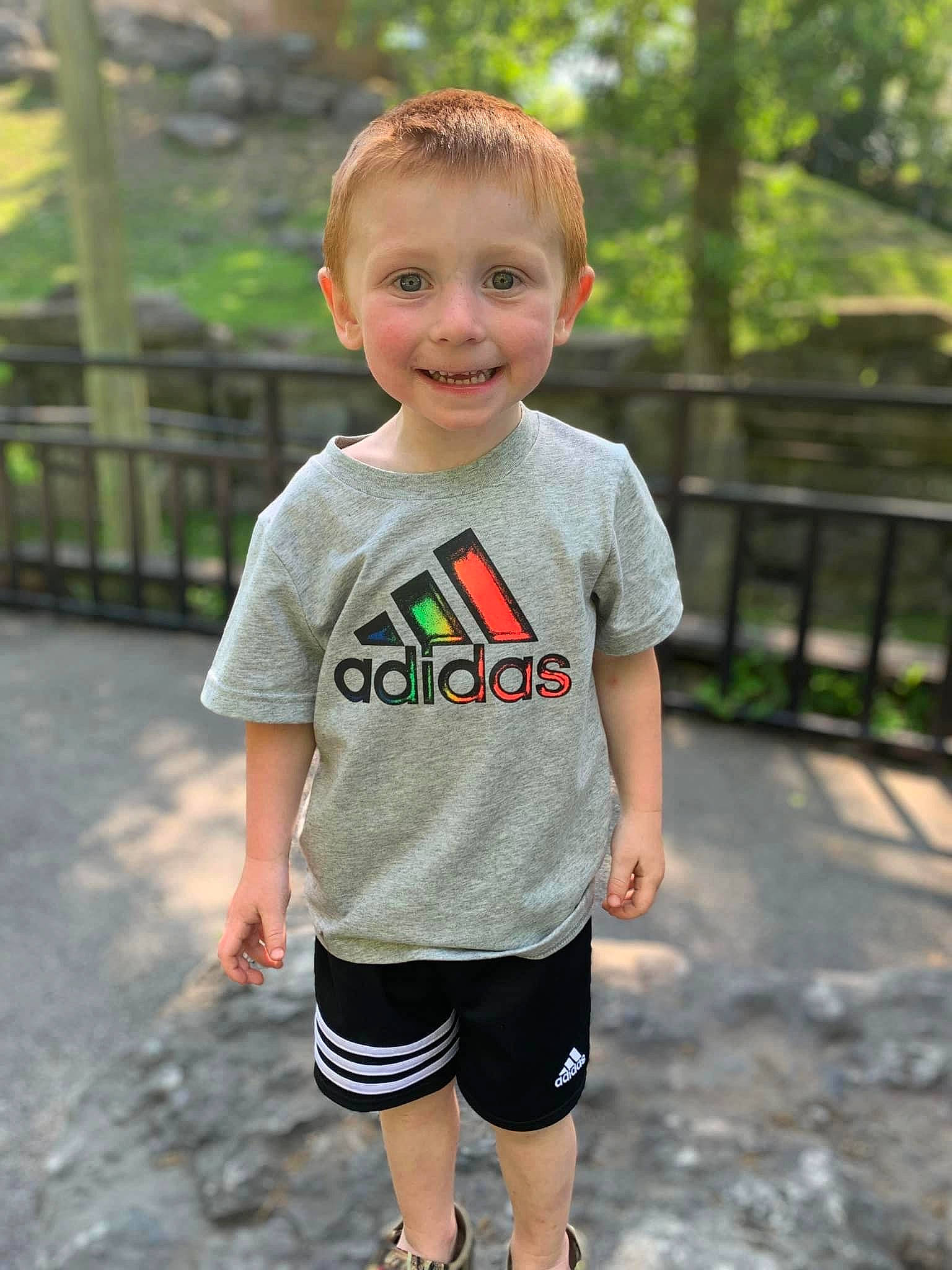 Hunter is registered to the contest to win money with this photo: baby_toddler_clothing, child, face, fence, fun, grass, hair, happy, joy, leisure, pattern, person, plant, recreation, shorts, sleeve, smile, sportswear, summer, t_shirt