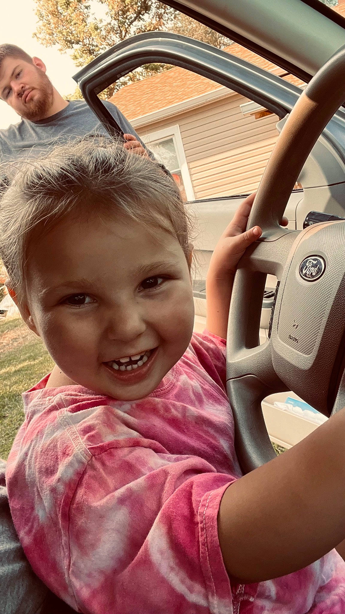 Evie joined the competition — help win amazing prizes! automotive_exterior, automotive_mirror, car, car_seat, chin, eye, gesture, happy, head, joy, motor_vehicle, organ, person, skin, smile, steering_part, steering_wheel, toddler, travel, vehicle