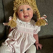 Jouney joined the competition — help win amazing prizes! baby, blue_eyes, child, couch, cozy, cute, face, happy, indoor, infant, pigtails, pink_dress, pink_ribbons, playful, portrait, sitting, smiling, soft_lighting, white_tights, yarn_wig