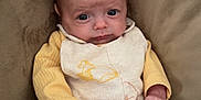 Mateo joined the competition — help win amazing prizes! baby, infant, child, face, person, clothing, yellow_sweater, winnie_the_pooh, blanket, couch, seated, cute, soft_texture, indoors, young, portrait, small_hands, expression, cozy, comfort
