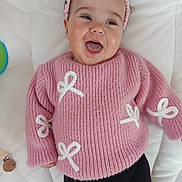 Joye a rejoint le concours — aidez-le/la à gagner de superbes lots ! baby, smiling, pink_sweater, headband, white_bows, lying_down, happy, infant, cute, child, indoor, soft_surface, black_pants, closeup, portrait, person, toddler, young_child, apparel, playful