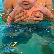 Enzo is registered to the contest to win money with this photo: adult, baby, child, closeup, cute, face, fun, hands, happy, holding, outdoor, parent, person, play, pool, skin, smile, summer, swimming, water