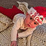baby, child, christmas_hat, red_pants, white_shirt, crawling, blanket, crochet, indoor, floor, holiday, festive, cute, person, young_child, rosy_cheeks, curious, infant, headwear, cozy