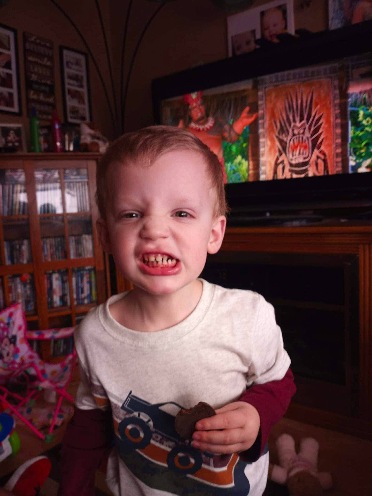 Earl is registered to the contest to win money with this photo: baby, baby_toddler_clothing, bookcase, cheek, child, eye, fun, happy, head, holiday, iris, mouth, nose, person, picture_frame, shelf, sitting, sleeve, smile, t_shirt