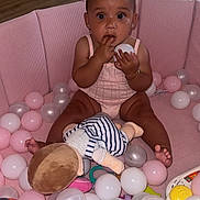 Reasiah Elohor joined the competition — help win amazing prizes! baby, ball_pit, balls, bracelet, child, clothing, colorful, curious, earrings, floor, indoor, person, pink, play, plush_doll, sitting, skin, toy, wide_eyes, wood_floor