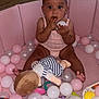 baby, ball_pit, balls, bracelet, child, clothing, colorful, curious, earrings, floor, indoor, person, pink, play, plush_doll, sitting, skin, toy, wide_eyes, wood_floor