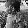 child, toddler, profile, black_and_white, bubbles, outdoor, grass, playground, slide, short_sleeve, curly_hair, earring, young_child, nature, daylight, cute, innocence, portrait, side_view, fun