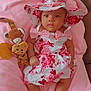 Ella participe au concours pour gagner de l'argent avec cette photo : baby, infant, child, pink_blanket, floral_dress, sunhat, plush_toy, giraffe_toy, cute, soft_fabric, indoors, couch, relaxed, portrait, smiling, happy, comfort, lying_down, skin, face