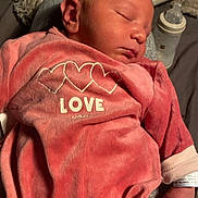 Ezio participe au concours pour gagner de l'argent avec cette photo : newborn, baby, sleeping, pink_clothing, heart_design, love_text, infant, soft_texture, baby_bottle, cozy, peaceful, resting, cute, tiny_hand, portrait, indoors, blanket, person, child, sleep