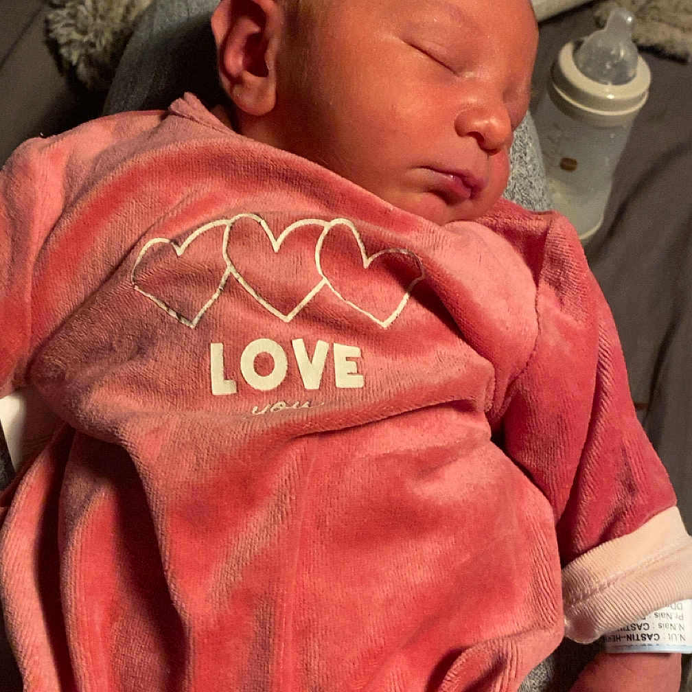 Ezio participe au concours pour gagner de l'argent avec cette photo : baby, baby_bottle, blanket, child, cozy, cute, heart_design, indoors, infant, love_text, newborn, peaceful, person, pink_clothing, portrait, resting, sleep, sleeping, soft_texture, tiny_hand