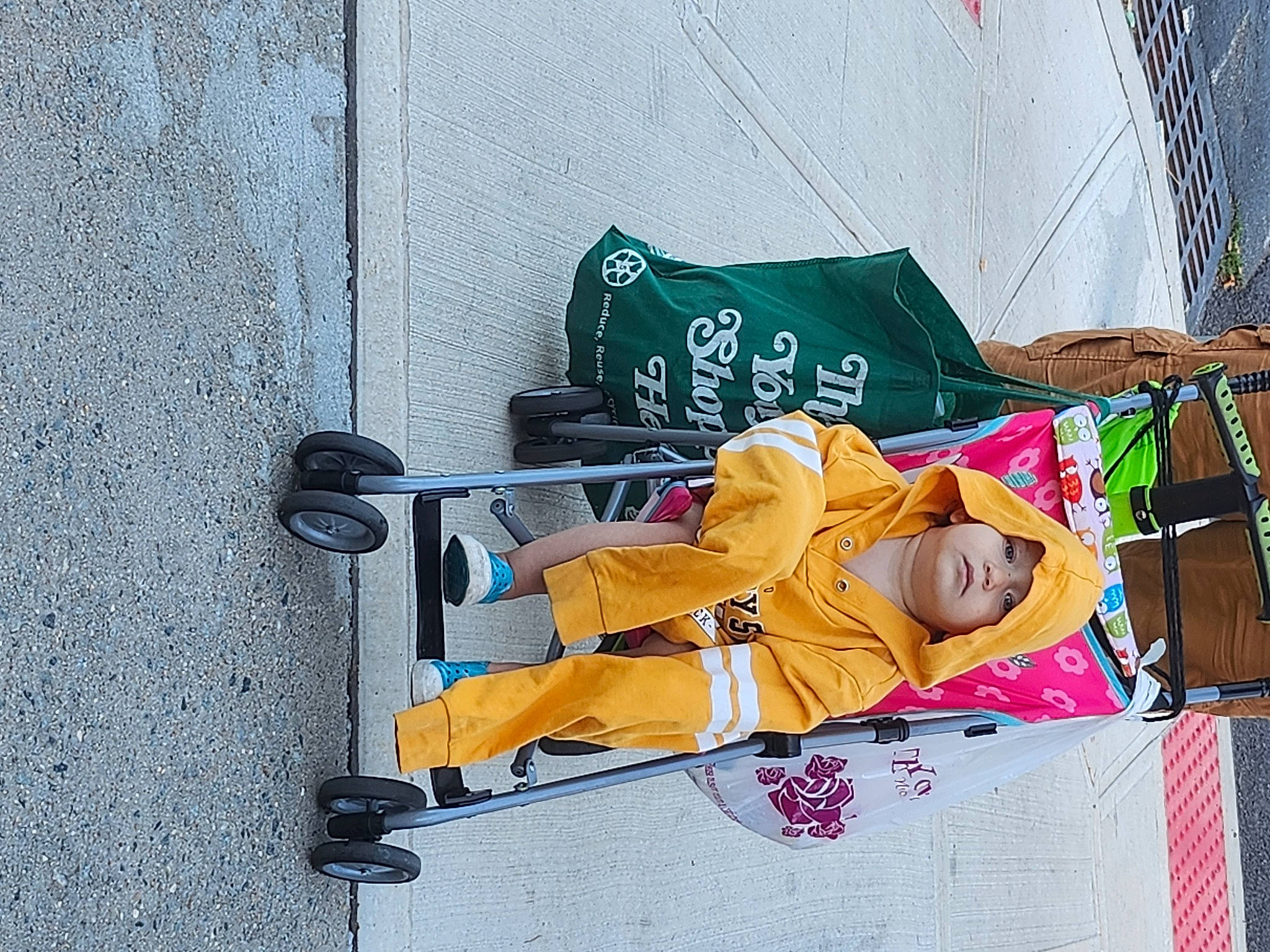 Azalia Hajar is registered to the contest to win money with this photo: asphalt, baby_carriage, baby_products, baby_toddler_clothing, concrete, headwear, leisure, person, recreation, rolling, shadow, sidewalk, sitting, sports_equipment, tire, toddler, wheel