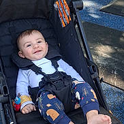 Jasper is registered to the contest to win money with this photo: baby, stroller, child, smiling, outdoor, playground, clothing, footwear, happy, person, seat, toy, sunlight, park, infant, cute, casual, relaxed, nature, daytime