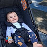 baby, stroller, child, smiling, outdoor, playground, clothing, footwear, happy, person, seat, toy, sunlight, park, infant, cute, casual, relaxed, nature, daytime