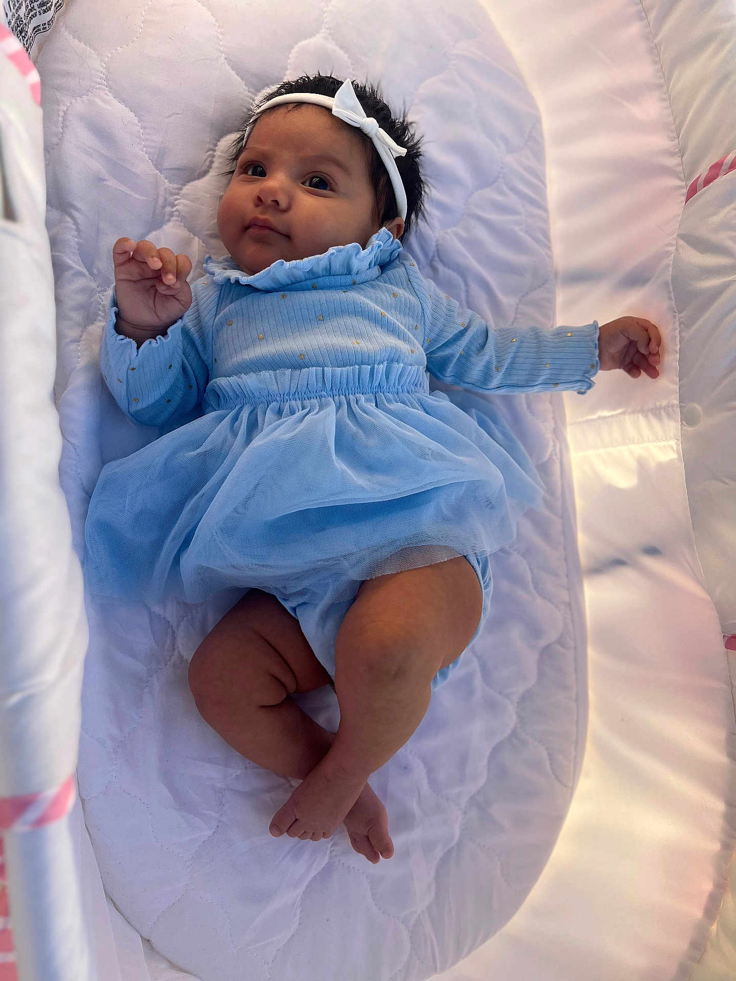Valerie joined the competition — help win amazing prizes! baby, infant, blue_dress, headband, lying_down, quilted_surface, white_background, cute, child, newborn, soft_lighting, indoors, portrait, small_hands, small_feet, curly_hair, comfortable, relaxed, clothing, adorable