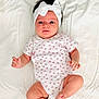baby, infant, headband, white_bow, onesie, floral_pattern, lying_down, bed, soft_sheet, cute, child, newborn, portrait, skin, small_hands, small_feet, looking_at_camera, indoors, comfortable, adorable
