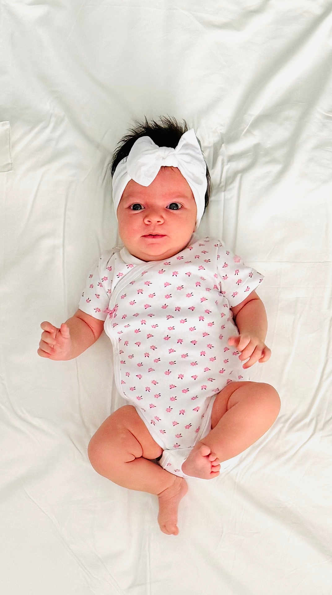 Line participe au concours pour gagner de l'argent avec cette photo : baby, infant, headband, white_bow, onesie, floral_pattern, lying_down, bed, soft_sheet, cute, child, newborn, portrait, skin, small_hands, small_feet, looking_at_camera, indoors, comfortable, adorable
