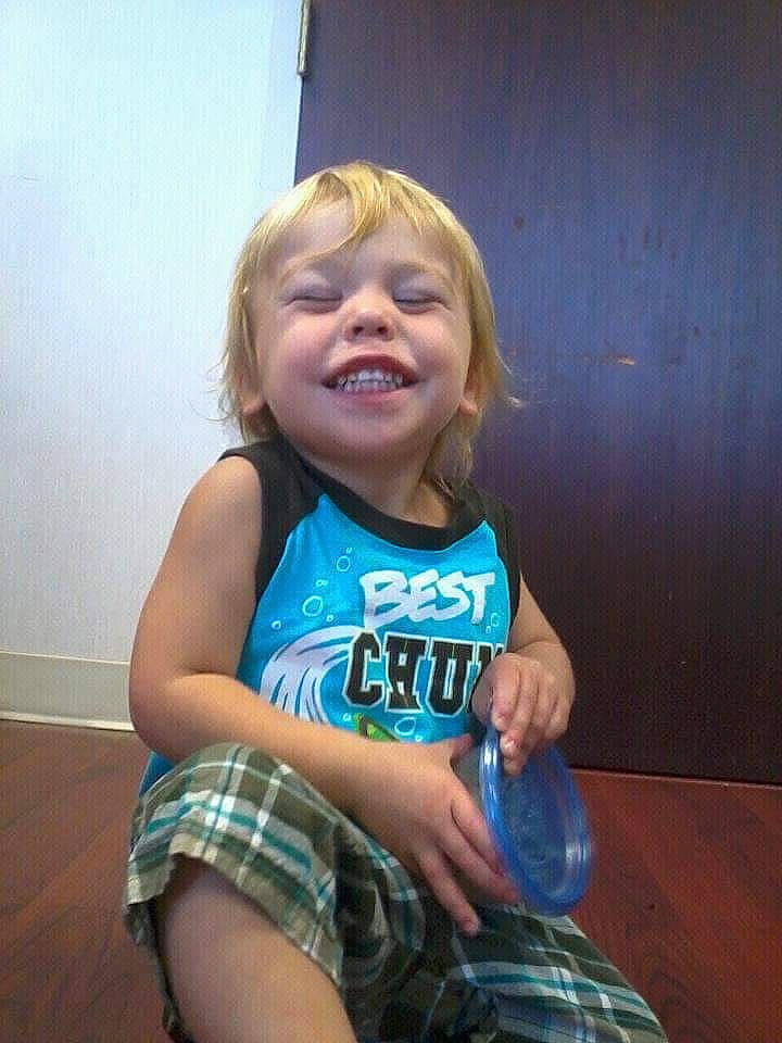 Maddox is registered to the contest to win money with this photo: baby_toddler_clothing, blond, cheek, elbow, electric_blue, finger, fun, gesture, happy, human_leg, joy, person, plaid, skin, sleeve, smile, t_shirt, tartan, thigh, thumb