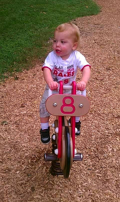 Maddox is registered to the contest to win money with this photo: automotive_wheel_system, baby, baby_toddler_clothing, bicycle, bicycle_accessory, child, fun, grass, happy, leisure, magenta, people_in_nature, person, recreation, riding_toy, sitting, soil, tire, toddler, vehicle